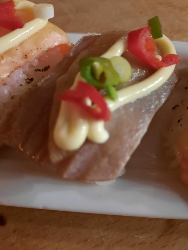nigiri flamed tuna. bosuitjes, Spaanse peper en gesmolten kaas met geflambeerde tonijn